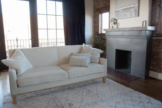 Lounge with a white sofa beside a fireplace